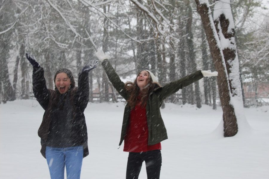 Carissa Vergeres and Mia Cammarota play in the snow.