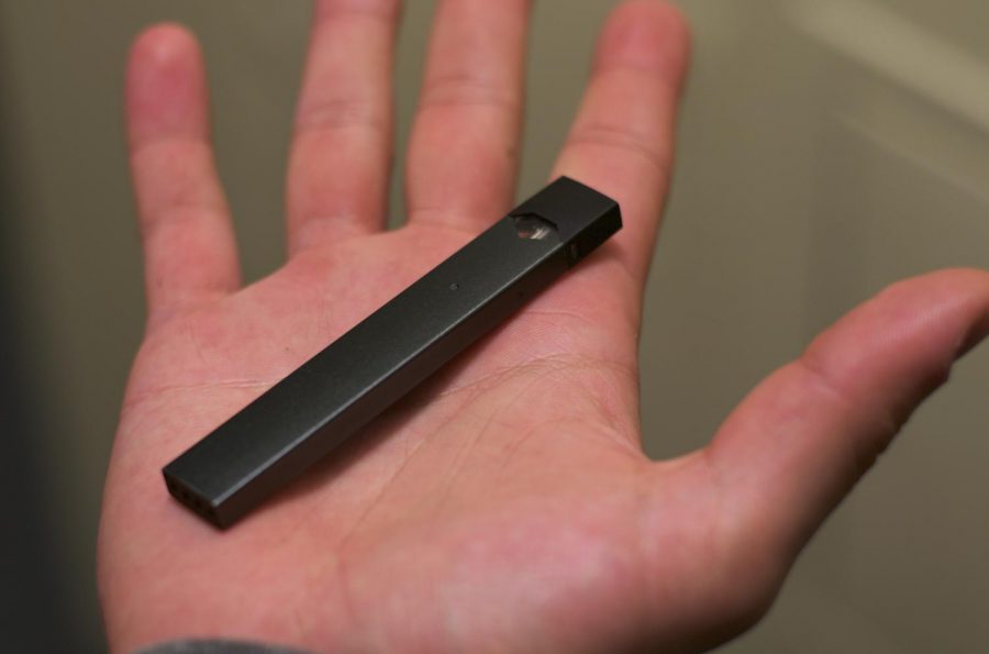 A consumer holds a Juul in their palm.