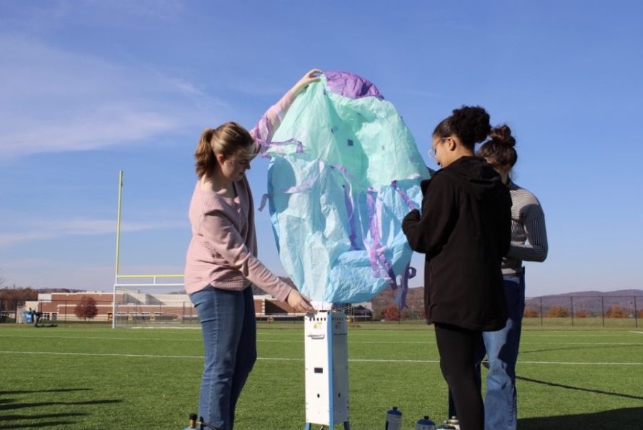 Teagan Russell , Elise Bortey and Jade Glackin prepare a hot air balloon for launch as part of a unit for Ms. Bingamans aerospace class.