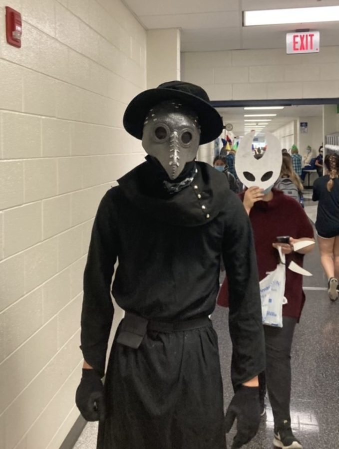 A student dresses up in a plague doctor attire for Halloween.