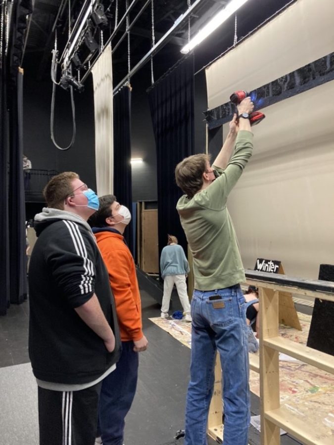 Thomas Louis and Cayden Wright watch as Jackson Marsh takes apart a flat (vertical set piece) in preparation for the upcoming one-act play.