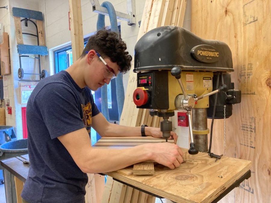 A student in Mr. Joses Tech Ed class uses a drill press on a piece of wood.