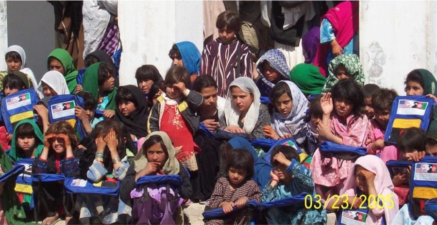 Backpacks, filled with supplies for girls, are passed out to school students.