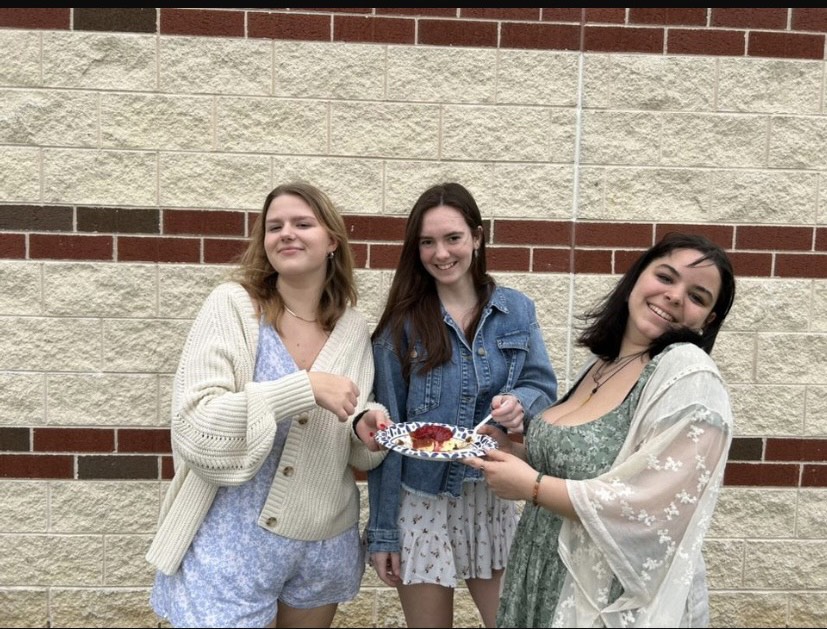 Photo of Outlander writers Ellia Mytsa, Ali Elliot, and Maeve Bauer (Left to right) enjoying a slice of cheesecake.