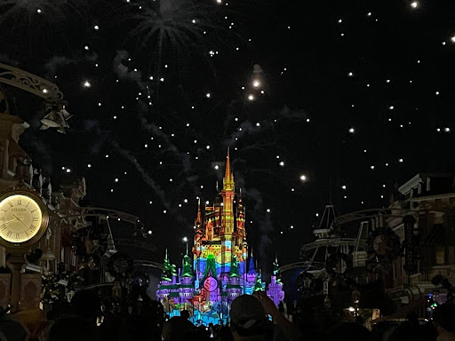 A Christmas event at Walt Disney World’s Magic Kingdom with Cinderella’s Castle with a rainbow projection on it and fireworks going off in the background. Photo provided by Lindsey Lincoln.
