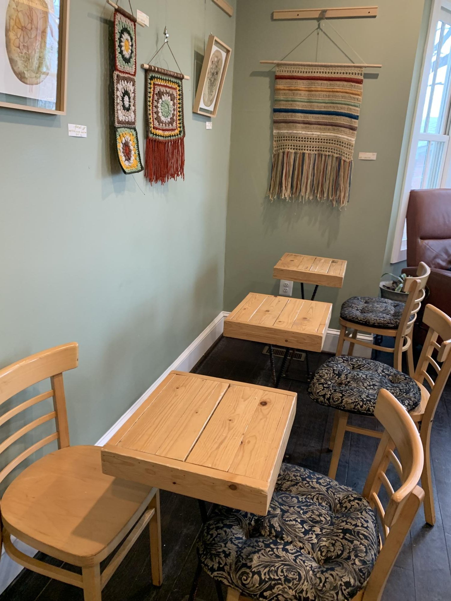 Small tables surrounded by art pieces at Doppio Bunny Coffee. Photo provided by William Den Herder.