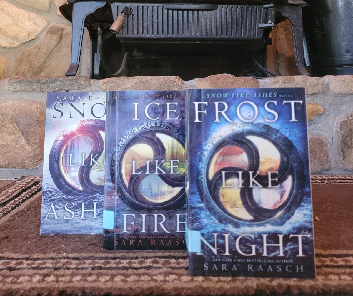The Snow Like Ashes series resting in front of a warm fireplace. Photo provided by Jillian Lewis.