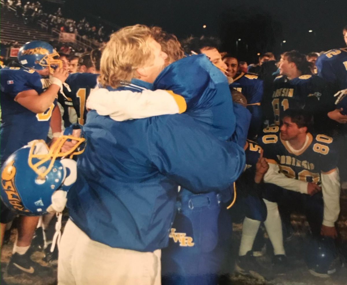 After leading the Robinson High School football team to become State Champions in 1997, assistant coach Bill Hildbold hugs his son, Joey Hildbold, the starting wide receiver and punter for the team. Photo provided by Bill Hildbold.