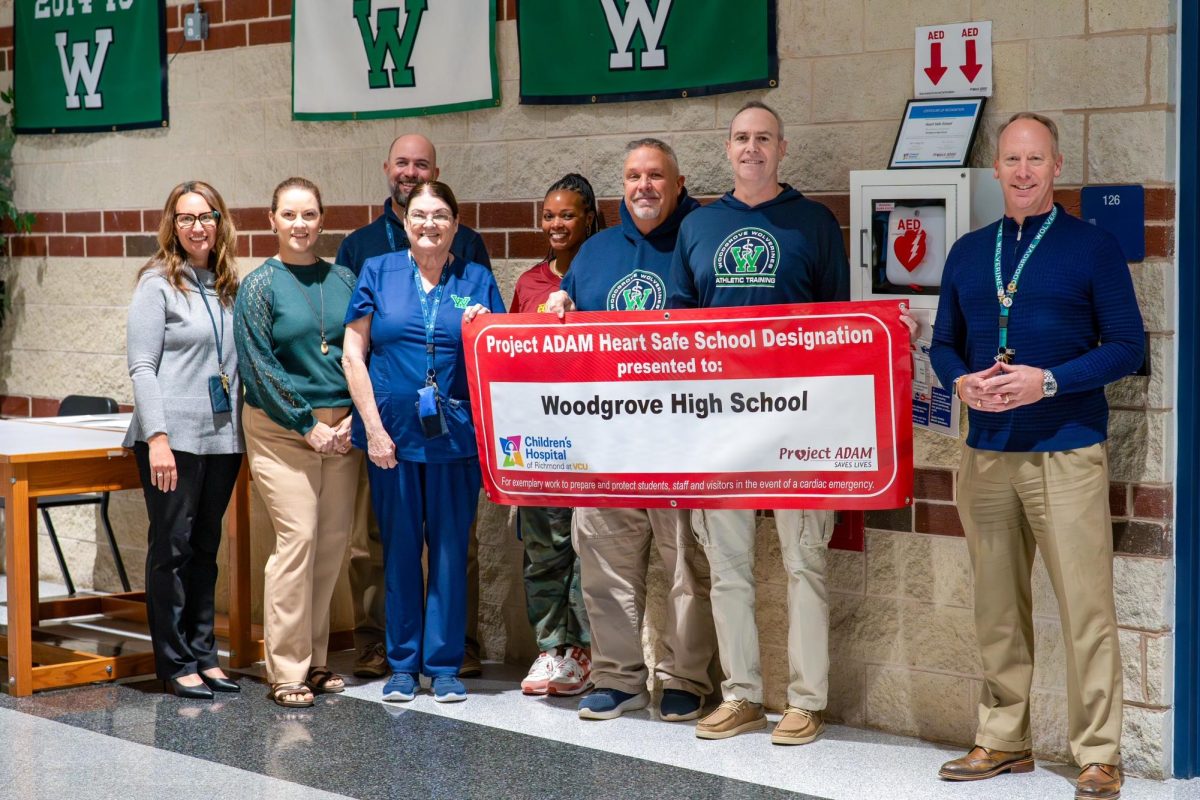 Woodgrove staff involved in making Woodgrove a Heart Safe School are from left to right Counseling Staff Geri Flore, Assistant Principal Christina Thompson, Assistant Principal Matthew Swartz, Head Nurse Stephanie Lovasz,  Assistant Principal Ebony Jackson, Athletic Trainer Assistant Mark Wagner, Athletic Trainer Paul Peterson, and Principal Dr. William Shipp all gathered around the school´s new banner. 