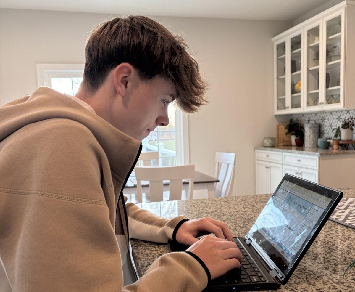 Reading the computer screen, senior Mason Byrne answers questions on his common app. Photo provided by Peyton Thomas.
