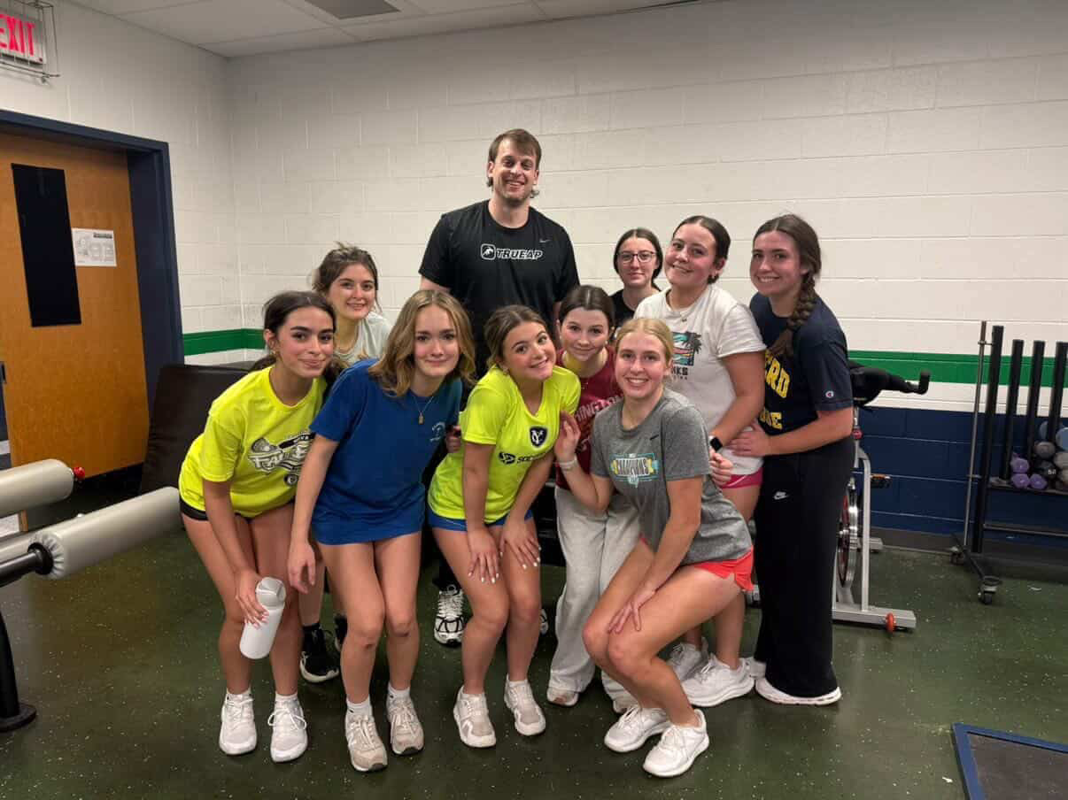 Billy Fierstein smiling with Woodgrove’s girls lacrosse players. Photo provided by Billy Fierstein.